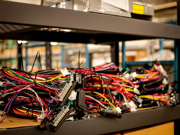 Labeled electrical cable assemblies and connectors organized on a production shelf.