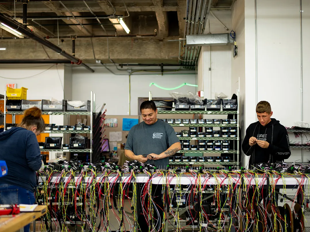 CI8 Group employees working on assemblies on the manufacturing floor.