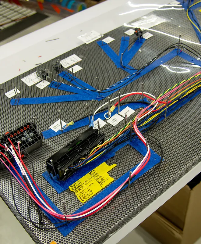 A custom wire harness laid out on an assembly board with connectors and routed branches.